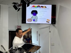 Man in white shirt pointing to ministry photo