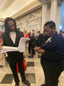 Networking with many with white papers explaining to another man.